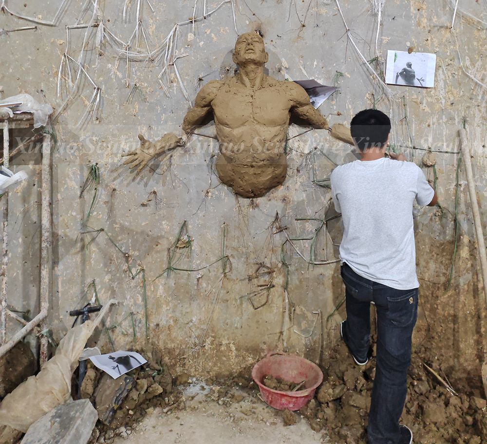 man coming out of the wall sculpture