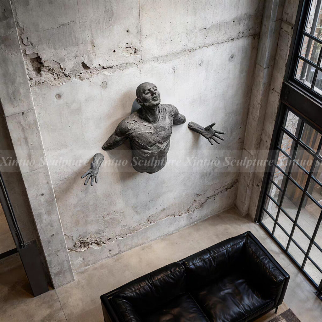man coming out of the wall sculpture