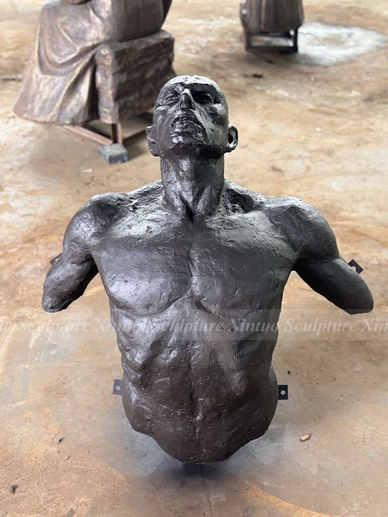 man coming out of the wall sculpture